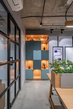 an office with wooden shelves and plants in them