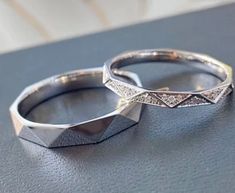 two wedding rings sitting on top of a table