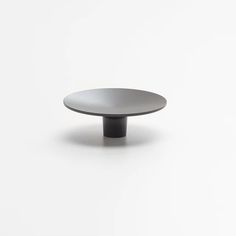 a black and white plate sitting on top of a white surface with no one around it