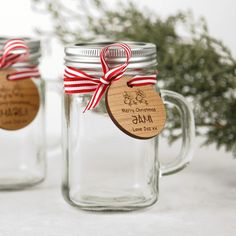 three mason jars with red and white striped ribbon tied around the lids, one is empty