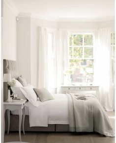 a bedroom with white walls and curtains on the windowsills is featured in an instagram