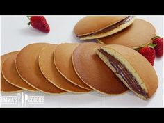 some cookies with chocolate and strawberries on the top one has a bite taken out