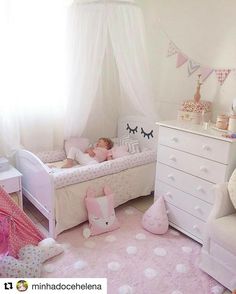 a child's bedroom with pink carpet, white furniture and curtains on the windowsill