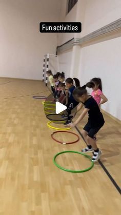 children are playing with hula hoops on the floor in an indoor gym area