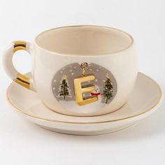 a coffee cup and saucer with the letter e on it