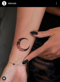 a woman's arm with a crescent tattoo on the left side of her wrist