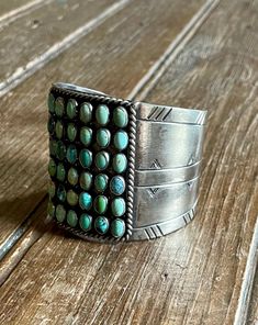 This unique bracelet from Paige Wallace is the perfect accessory for any look. Crafted from German silver, it features beautiful turquoise stones set in a wide cuff. Expertly carved and finished, it will add an eye-catching touch to any outfit. Features: Wide cuff Turquoise Stones Carved German Silver By Paige Wallace Turquoise Stones, Unique Bracelets, Wide Cuff, German Silver, Stone Settings, Turquoise Stone, Cuff Bracelet, Carving, Cuff