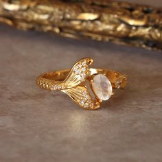 Elevate your style with the Sirena Ring, a gentle homage to the ocean's mystical allure. Designed for the girl who cherishes the sea, this elegant piece features a natural moonstone center stone, gracefully complemented by a delicate mermaid tail and intricate barnacle accents. Embrace your inner mermaid with this exclusive ring, offering a serene blend of whimsy and sophistication. Mermaid Rings Engagement, Mermaid Engagement Rings, Mermaid Inspired Jewelry, Ocean Inspired Rings, Mermaid Engagement Ring, Mermaid Rings, Sea Rings, Ocean Ring, Mermaid Vibes