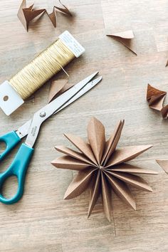 paper stars, scissors and spools of thread sit on a table next to origami