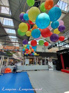 many colorful lanterns are hanging from the ceiling