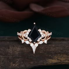 a black stone surrounded by white diamonds on top of a piece of wood