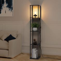 a living room with a couch and a lamp on the wall next to a book shelf