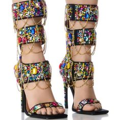 Destined To Be A Pop Culture Icon In The Azalea Wang " Layers Of London " Multi Embellished Sandal! Crafted Using A Satin Textile Upper, These Ornate Sandals Feature An Open Squared Toe Silhouette, A Mid-Calf Shaft Height, A Contrast Metallic Faux Leather Cushioned Insole, A Gemstone Embellished Slim Stiletto Heel, A Gladiator-Style Strappy Design, And A Slim Gemstone Embellished Toe Band. Complete With Colorful, Clustered Gem-Detailing And Cascading Rhinestone Link Accents Adorning The Shaft, A Spring Multicolor Heels With Rhinestones, Glamorous Multicolor Sandals For Spring, Multicolor High Heel Sandals With Rhinestones, Multicolor Rhinestone High Heel Sandals, Multicolor Rhinestone Sandals For Spring, Multicolor Embellished Heels With Round Toe, Glamorous Multicolor Open Toe Heels, Multicolor Rhinestones Heels For Evening, Multicolor Crystal Embellished High Heels