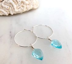 Dainty little aquamarine faceted crystal gemstone hoop earrings in 20mm sterling silver or 14k gold filled hoops. Option for gold plated and silver plated are less expensive. Please see drop down. Perfect for March birthdays! 💙Aquamarine, a stone of serenity, calms and soothes with it's lovely blue/green color and evokes the calm of the water with it's given name, which is interpreted at 'water of the sea' derived from Latin. A stone that celebrates the sea goddess of ancient times, it was carr Blue Hypoallergenic Small Hoop Jewelry, Hypoallergenic Blue Small Hoop Jewelry, Sterling Silver Hoop Crystal Earrings For Gift, Sterling Silver Gemstone Hoop Earrings, Blue Teardrop Gemstone Hoop Earrings, Blue Sterling Silver Hoop Jewelry, Blue Hoop Sterling Silver Jewelry, Blue Hoop Earrings In Sterling Silver, Everyday Sterling Silver Hoop Earrings With Birthstone