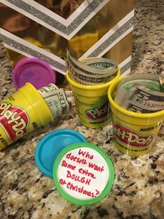 three cups with writing on them sitting on a counter next to a bag and some other items