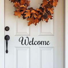 a welcome sign on the front door of a house with autumn leaves hanging from it