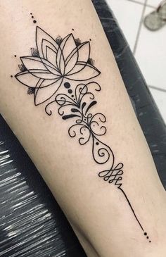 a black and white photo of a flower tattoo on the left arm with an arrow