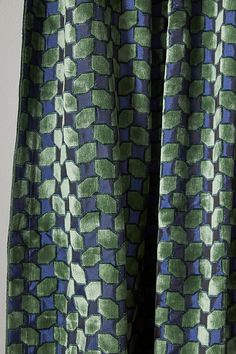 the back of a green and blue patterned curtain