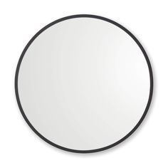 a round mirror on a white wall with black trimmings and an oval frame