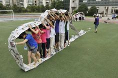 a group of people standing on top of a soccer field holding up their hands in the air