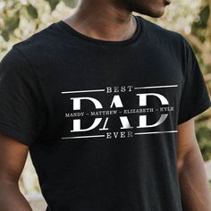 a man wearing a black t - shirt with the words best dad ever printed on it