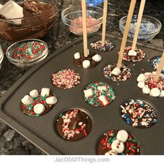 chocolate cupcakes with marshmallows and sprinkles on a baking tray