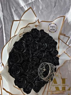 a bouquet of black roses with a ring on it