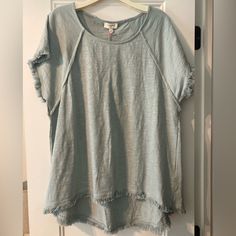 This Top Is A Beautiful Light Greenish Gray Color. The Fringe On The Sleeves And Bottom Is So Cute. It Doesn’t Fit Me And Has Never Been Worn. Light Wash Short Sleeve Top With Frayed Hem, Summer Crew Neck Top With Frayed Hem, Casual Cotton Blouse With Frayed Hem, Summer Short Sleeve Tops With Frayed Hem, Casual Summer Blouse With Frayed Hem, Light Wash Tops With Frayed Hem For Day Out, Summer Light Wash Tops With Frayed Hem, Light Wash Tops With Frayed Hem For Summer, Umgee Tops