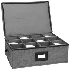 an open gray box with six compartments on the inside and four white plates in it