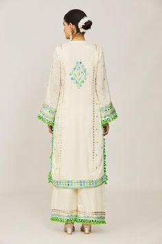 Ivory straight kurta with mirror, sequin, pompom and tassel details. Paired with an embroidered palazzo and embroidered dupatta.
Components: 3
Pattern: Embroidered
Type Of Work: Hand and machine embroidery
Neckline: Round
Sleeve Type: Long
Fabric: Kurta: Viscose, Palazzo: Linen Satin, Dupatta: Chiffon 
Color: Ivory
Other Details: 
Tasseled hem and sleeves
Occasion: Mehendi and Haldi - Aza Fashions Gopi Vaid, Embroidery Neckline, Palazzo Set, Straight Kurta, Set For Women, Aza Fashion, Machine Embroidery, Types Of Sleeves, Custom Made