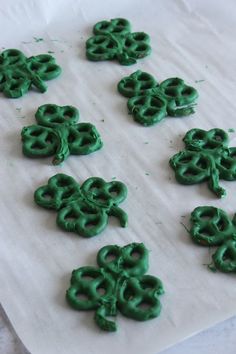 green pretzels sitting on top of a white sheet of wax paper with holes in the middle