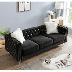 a black couch with white pillows in a living room