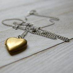 "A vintage brass heart locket hangs from a vintage stainless steel chain to make this simple and easy to wear necklace. The locket measures 7/8\" long and is NOS (new old stock) vintage with varying amounts of patina and scratches on the surface. Choose length at checkout: 16\". 18\". 20\". 22\". 24\". More heart jewelry can be found here: http://etsy.me/1Stzj2o To see more of my handmade jewelry in my Etsy shop, click this link: WearYourWild.etsy.com All jewelry comes securely nestled in rustic Vintage Heart Pendant Locket Necklace With Adjustable Chain, Vintage Heart Locket Necklace With Adjustable Chain, Heart-shaped Brass Necklace With Adjustable Chain, Gold Brass Heart Pendant Locket Necklace, Vintage Heart Necklace With Adjustable Chain, Gold Heart Pendant Locket Necklace In Brass, Brass Heart Pendant Locket Necklace With Vintage Charm, Vintage Charm Heart-shaped Brass Necklace, Brass Heart Charm Locket Necklace