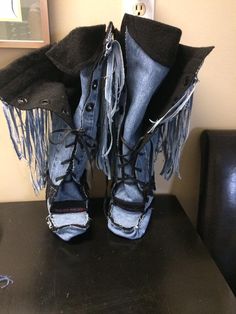 a pair of blue jeans with fringes on them are sitting on a black table