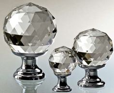 three crystal knobs are shown on a reflective surface