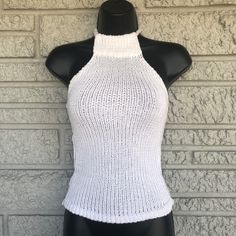 a mannequin wearing a white knitted halter top on a black dummy