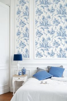 a bedroom with blue and white wallpaper on the walls