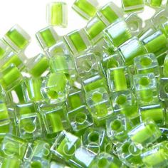 green and white glass beads are scattered together