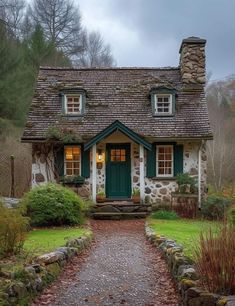 a stone cottage with green shutters and windows on the front door is lit up at night