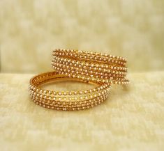 "❖ ❖ ❖ Features: ❖ An Indian styled beaded bangles. ❖ Made from fine Quality Brass with Gold Platting. ❖ Ready to be given as a gift. ❖ Easy and Convenient way to Wear ❖ It looks prettier than the images. Direct Images on hand is also attached. Size of Bangle & Other Details ❖ Size:- 2.5\" approx / Choose Your Size ❖ Quantity:- 12 Bangle Set ❖ Material:- Fine Quality Brass with Gold Platting This gold plated unique bracelet is glamorously impressive, yet subtle, the design is clean and extre Traditional Beaded Bangle For Wedding, Traditional Wedding Beaded Bangle, Gold Beaded Bangle For Wedding, Beaded Bangle For Wedding And Festive Occasions, Festive Beaded Wedding Bangle, Festive Wedding Beaded Bangle, Gold Bangle With Round Beads For Wedding, Gold Beaded Bracelets For Wedding, Silver Beaded Bracelets For Wedding And Festivals