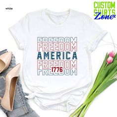 a white t - shirt with the words freedom and america on it next to some flowers