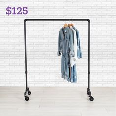 a clothes rack with two shirts hanging on it's sides and three black wheels