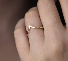 a woman's hand with a gold ring on it