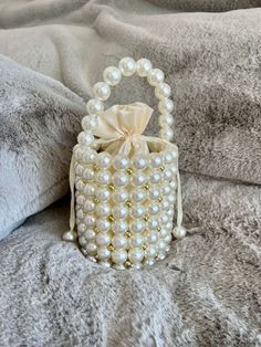 Beautiful Pearl Beaded Bag. Perfect for your wedding day or any special occasion. Comes with an internal satin pouch with peal drawstring and long handle. 16cm high 13.6cm wide Washing Instructions: Spot Clean Clean Processing Time: I aim to process all orders within 2-3 business days. If you require an item by a certain date please contact me before placing your order. If I am able to I will happily fast-track your order.     Returns: Returns are accepted under exceptional circumstances only and will be subject to a 20% restocking fee. Buyer is expected to cover return postage. *No Returns on customised orders*  Please contact me if you have an issue with your order and I will gladly assist. Shipping: UK orders will be sent using Royal Mail Signed for 1st Class International Orders will b White Beaded Bag, Elegant Bucket Evening Bag For Wedding, Cream Bucket Bag With Pearl Handle, Elegant Wedding Bucket Evening Bag, Cream Bucket Shoulder Bag With Pearl Handle, Gold Pearl Shoulder Bag For Wedding, Wedding Gold Pearl Shoulder Bag, Cream Evening Bag With Pearl Handle For Gift, Cream Evening Bag With Pearl Handle As Gift