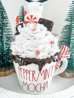 a cup filled with whipped cream and peppermint mocha on top of a table