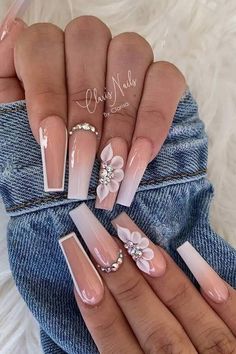 a woman's nails with pink and white flowers on the tip of their fingernails