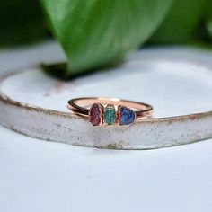 three stone ring sitting on top of a white surface