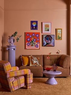 a living room filled with furniture and pictures on the wall