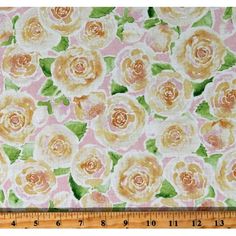 a pink and yellow flowered fabric with green leaves on the bottom, next to a ruler