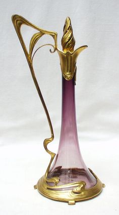 a purple and gold vase sitting on top of a white table